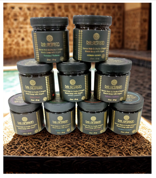 “Be Artisan Saffron & Argan Black Soap jars displayed on Moroccan decor, natural exfoliating black soap with saffron.”